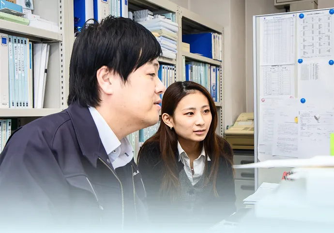 資料を確認しながら打ち合わせを行う社員