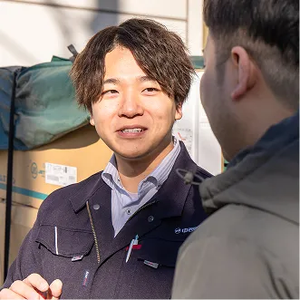 屋外でお客様と打ち合わせを行う社員