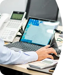 ノートパソコンで業務管理を行う社員