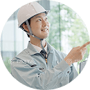 図面を確認しながら指差し確認を行うヘルメット姿の作業員