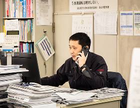 デスクで電話対応をしながら業務を行う社員