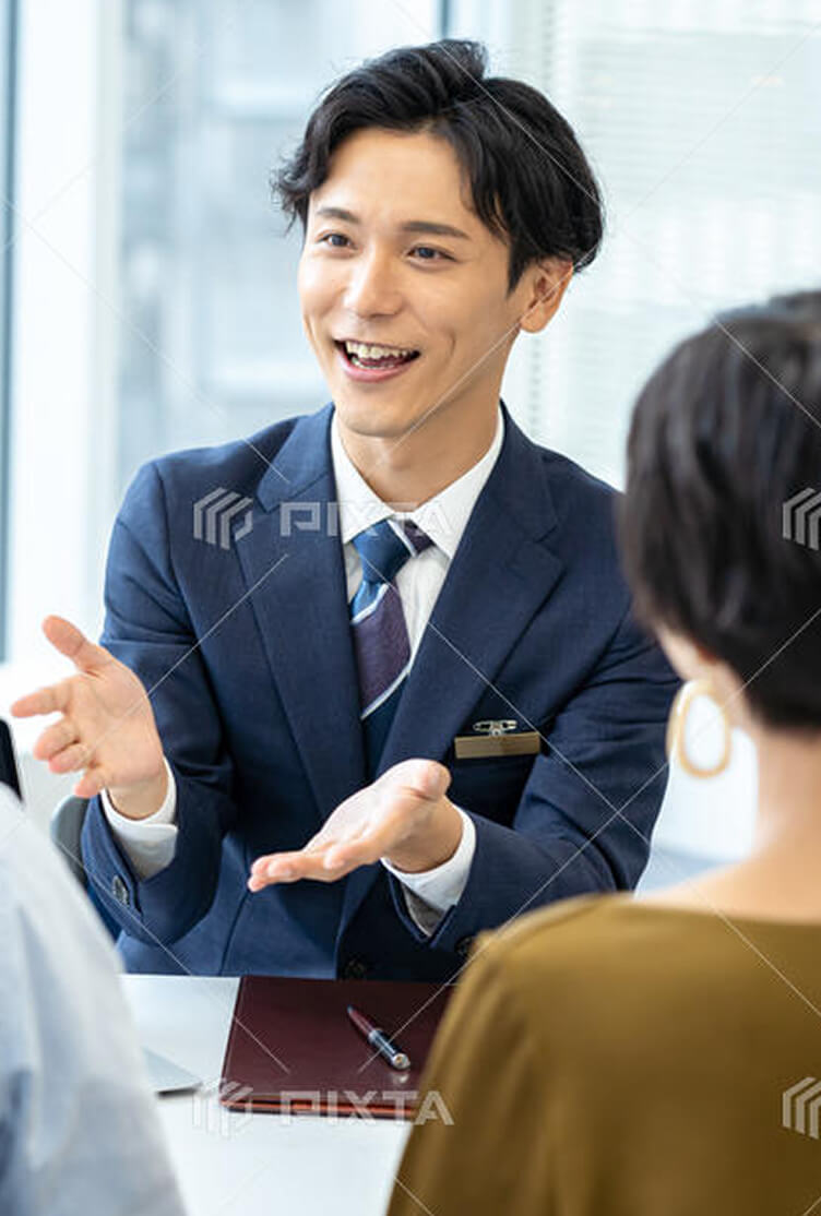 顧客に笑顔で説明をするスーツ姿の男性営業担当者