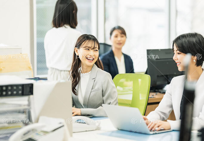 オフィスで談笑しながら仕事をする若手社員