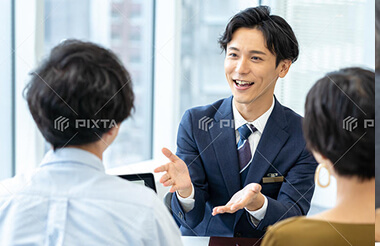 スーツ姿の男性社員がお客様に説明をしている様子